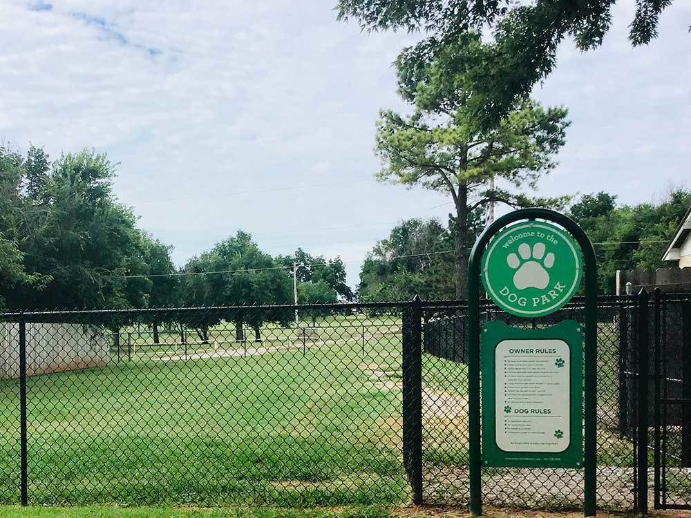 The fenced dog park, with its welcome sign and owner rules